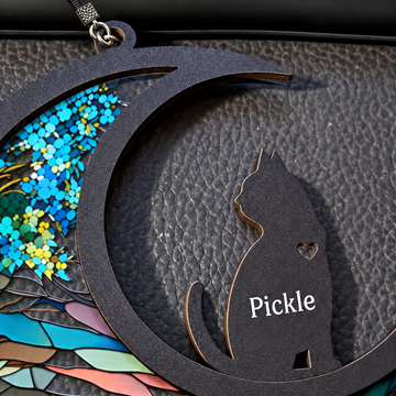 Close view of the cat memorial crescent showing textured dark wood, clear printed acrylic, name and silver-chain eyelet