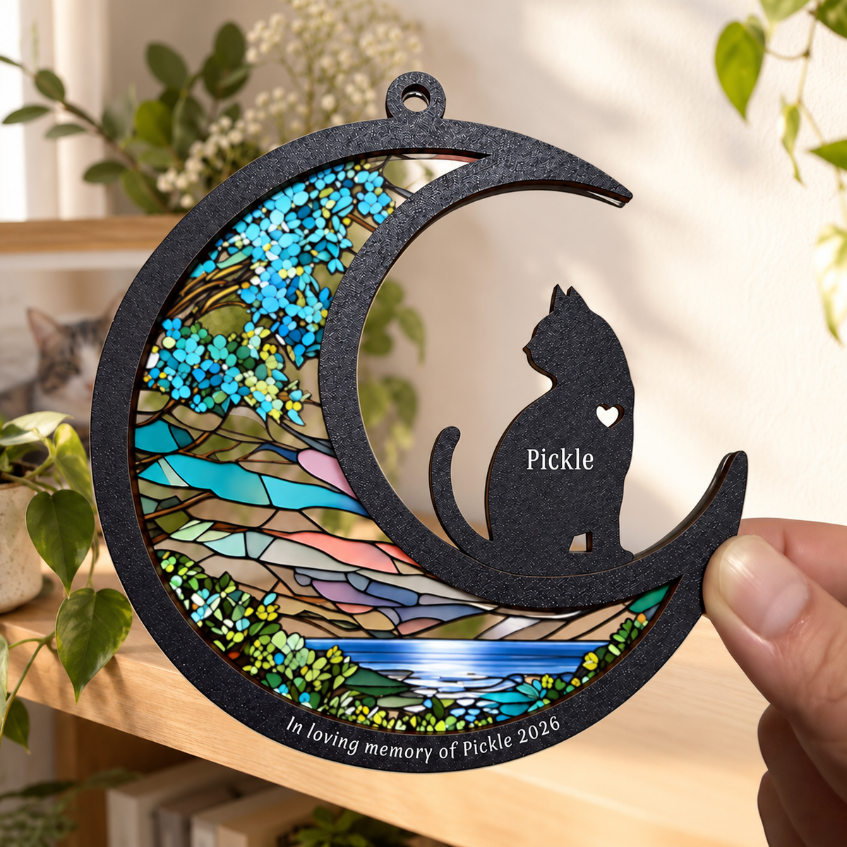 Cat memorial crescent ornament example held in a hand, showing 5-inch scale and clear printed acrylic