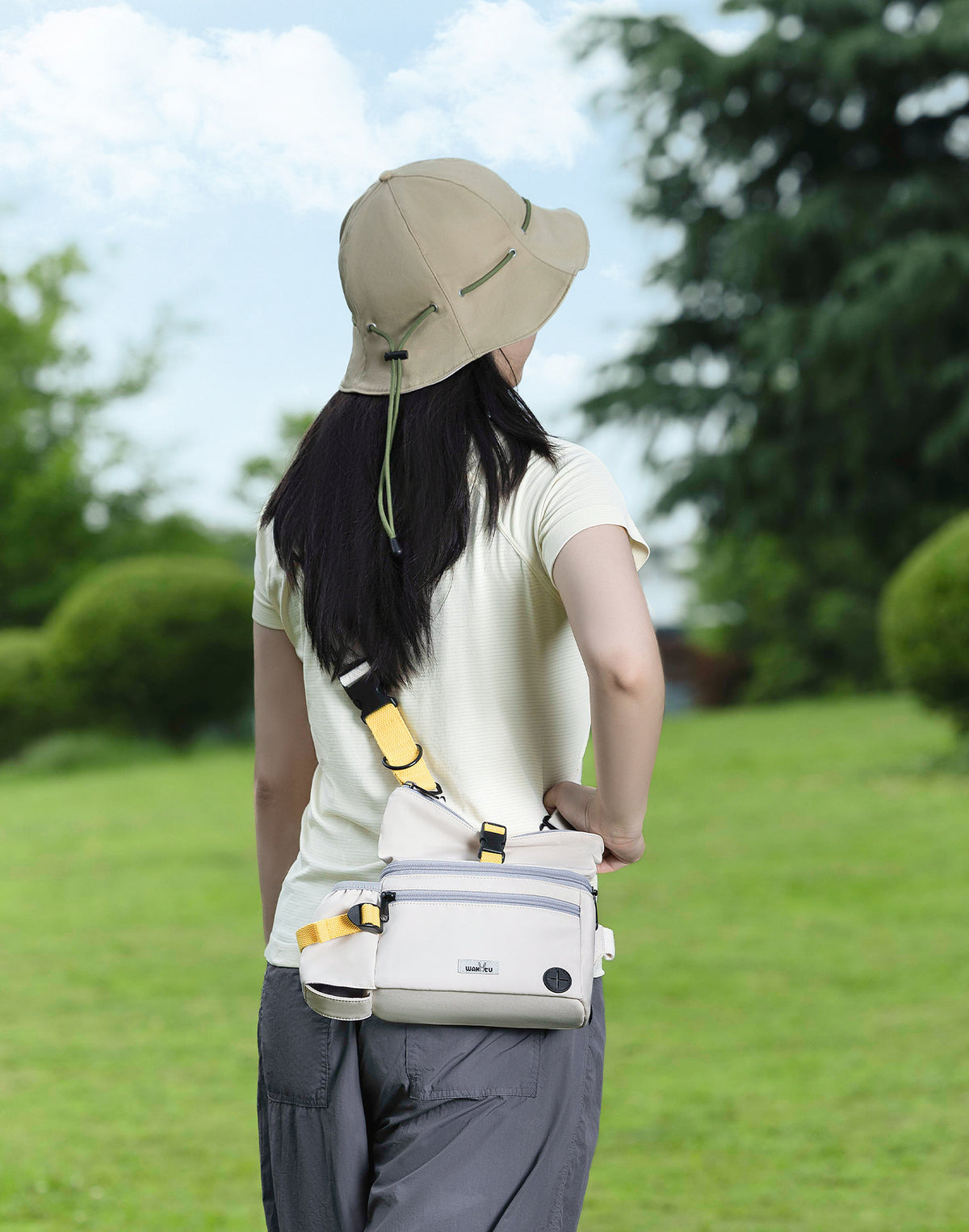 Adult wearing the ivory C280 across the shoulder in supplier outdoor photograph.