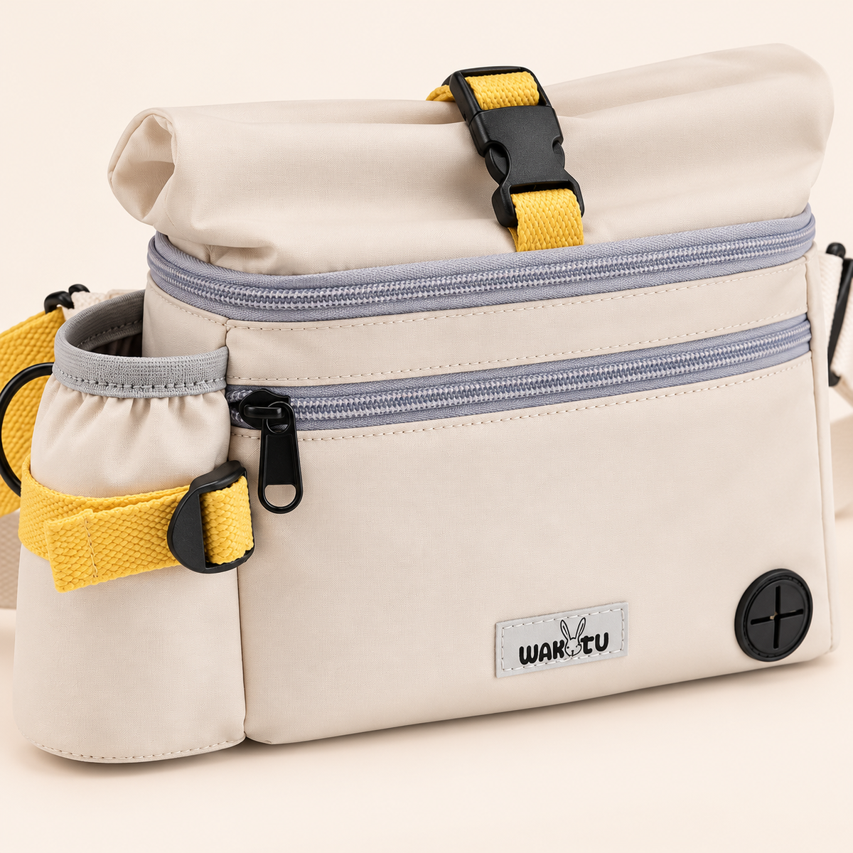 Supplier-based close illustration of the ivory bag front, gray zips, WAKYTU patch and round waste-bag outlet.