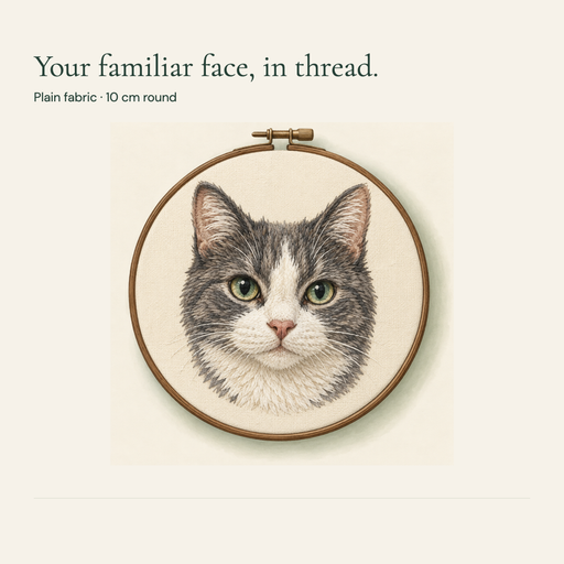 Gray and white cat portrait in a round plain fabric embroidery hoop.