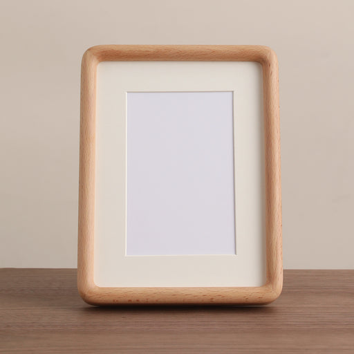Empty rounded light-beech frame with an ivory mat.