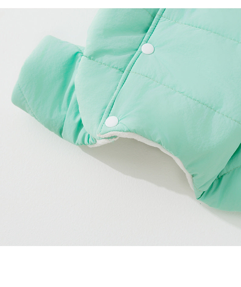 Close-up of white back-placket fasteners and the adjacent opening on the green coat.