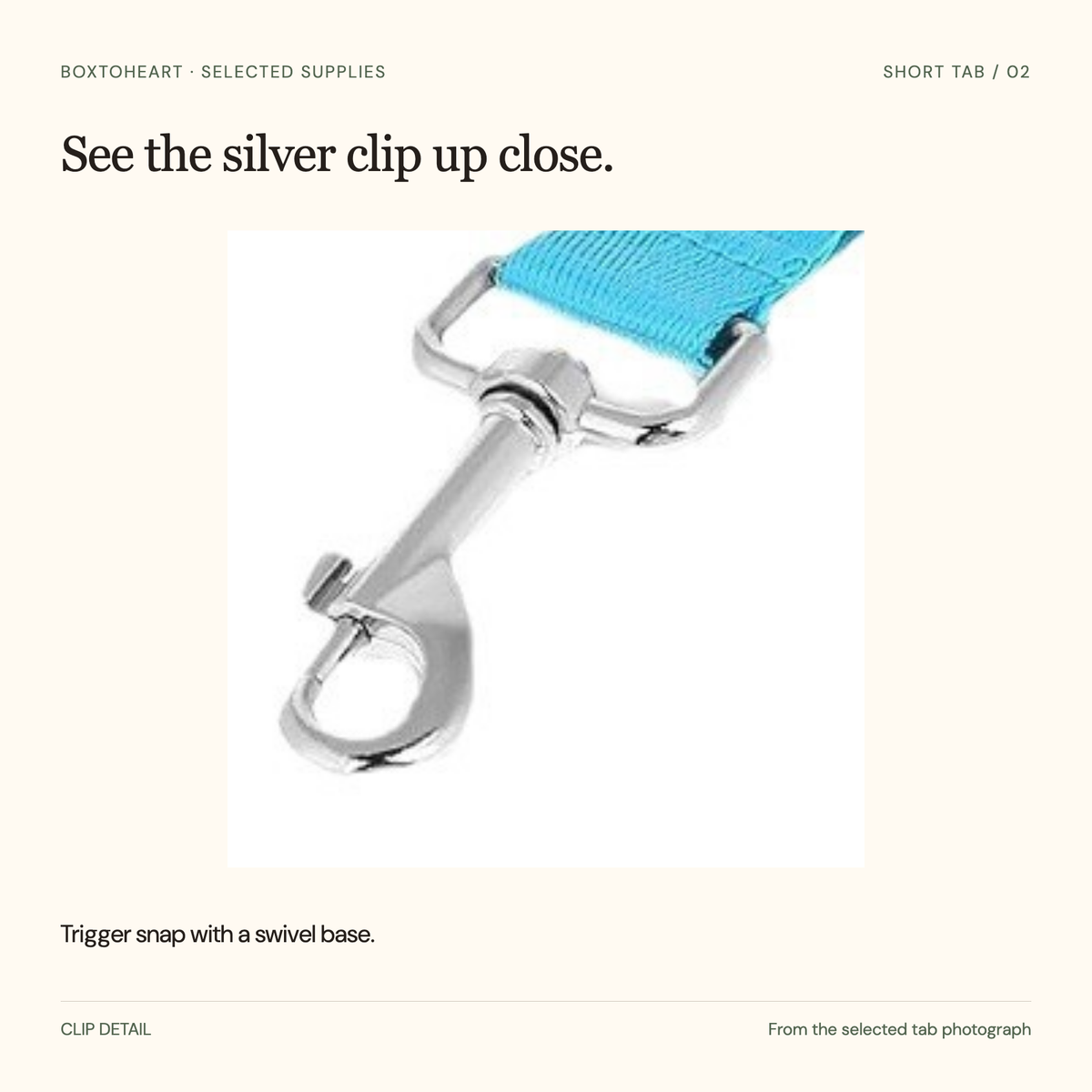 Detail of the silver trigger snap and swivel base on the selected sky-blue tab.