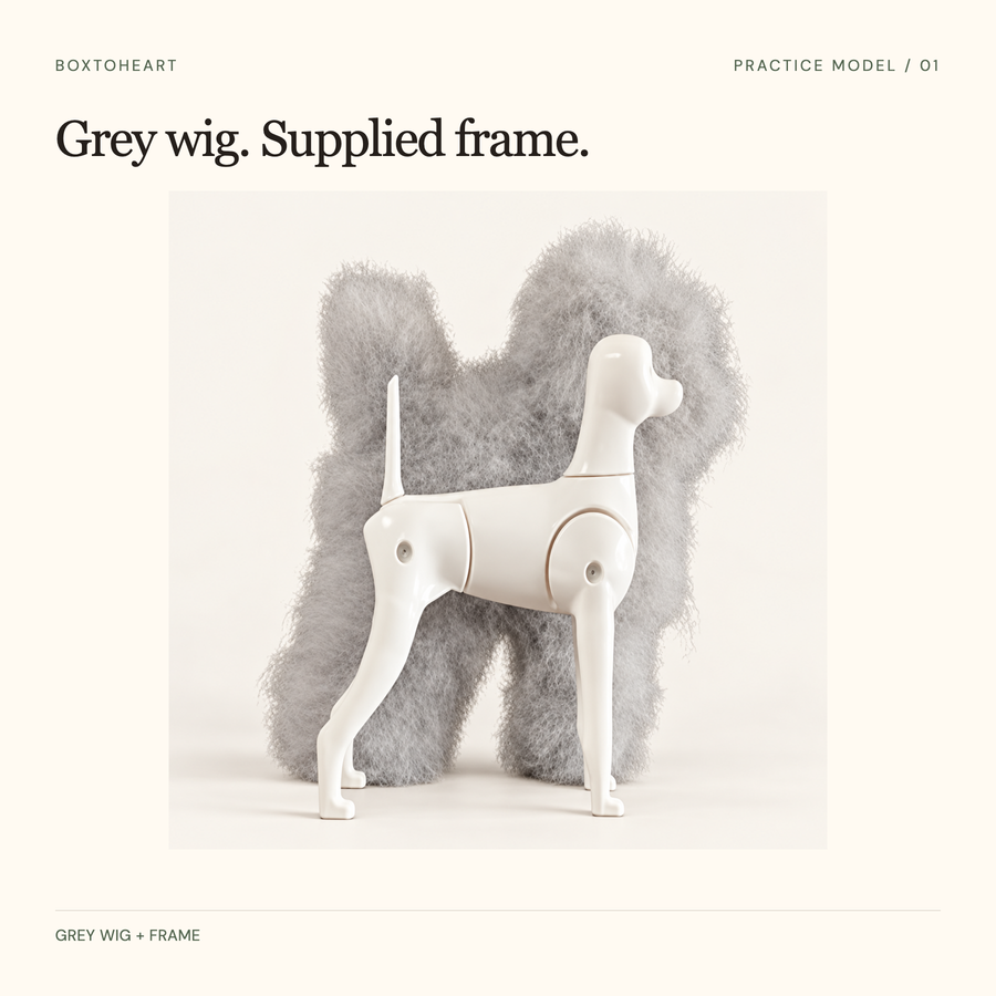 Paired grey full-body practice wig behind its separate white frame, against a warm background.