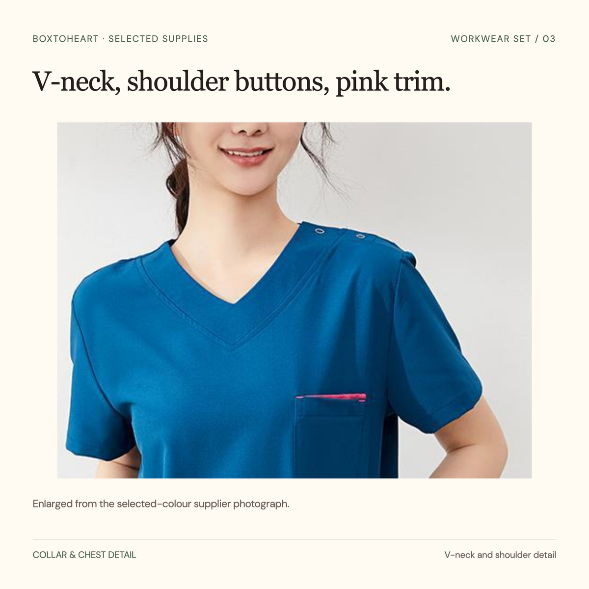 Unretouched enlargement of the peacock-blue V-neck, two small shoulder buttons and chest patch pocket with pink trim.